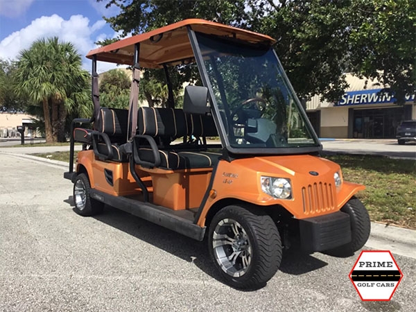 Orange Tomberlin 6 Passenger Golf Cart on the top of the world golf cart rental, golf cart rentals